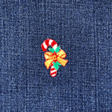Christmas-themed candy cane and bow patch on denim fabric