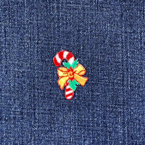 Christmas-themed candy cane and bow patch on denim fabric