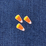 Three candy corn-shaped patches on a denim background