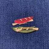 Embroidered patch set of a red canoe and green canoe on denim fabric