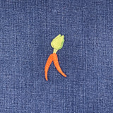 Embroidered carrot patch with green top on blue denim fabric