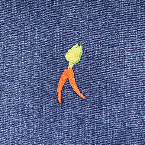 Embroidered carrot patch with green top on blue denim fabric