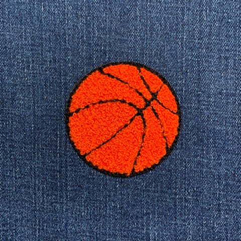 chenille basketball patch on a blue denim background