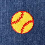 Yellow softball patch with red stitching on blue denim fabric