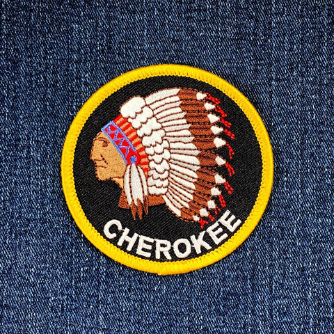 Patch with a Native American head design and 'Cherokee' text on denim fabric.