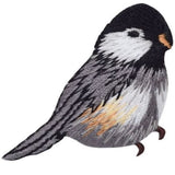 Embroidered patch of a bird with black, white, and brown colors on a white background