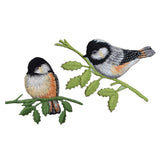 Two embroidered bird designs on a branch with leaves against a white background