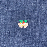 Embroidered patch of Christmas bells with holly leaves and berries on blue denim fabric.