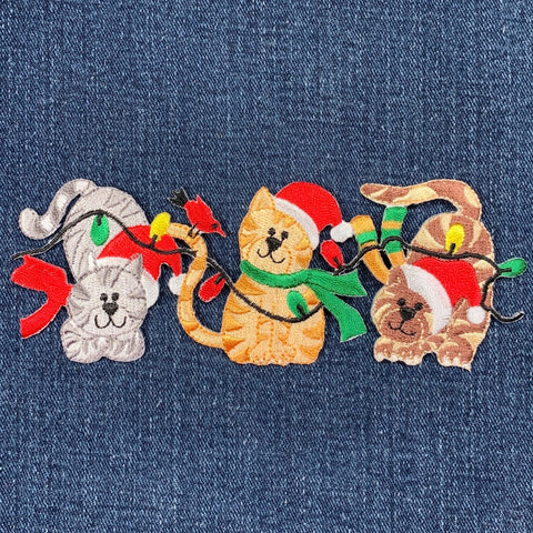 Embroidered patch of cats in festive Christmas attire on denim fabric