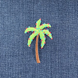 Embroidered palm tree with colorful lights on denim fabric