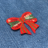 Red bow patch with sequins on a denim background