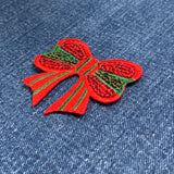 Red and green bow patch on denim fabric