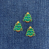 Three embroidered Christmas tree patches on a denim background