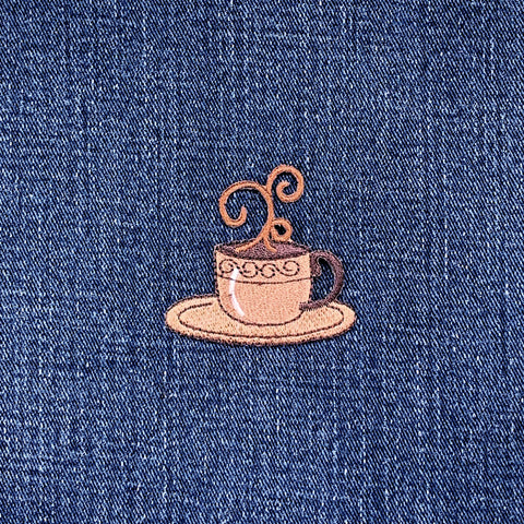 Embroidered patch of a coffee cup and saucer on a denim background