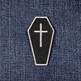 Coffin-shaped patch with a cross on denim fabric