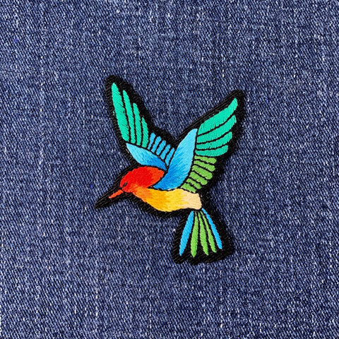 Colorful bird patch on denim fabric