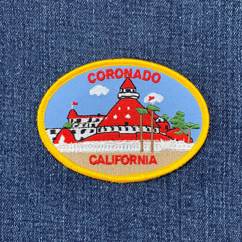 Oval embroidered patch for Coronado, California, featuring the distinctive red turreted roof and white walls of the Hotel del Coronado.