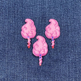 Three pink cotton candy patches on a denim background