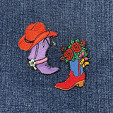 2 embroidered patches on denim fabric featuring a cowboy hat, purple boot, and a red and blue boot with flowers.