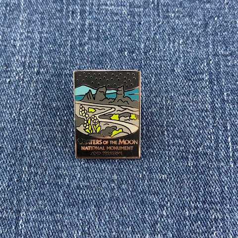 Pin with Craters of the Moon National Monument design on a denim background