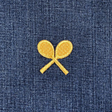 Two gold tennis rackets patches on a blue denim fabric.