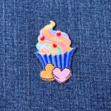 Colorful cupcake patch with hearts on denim fabric