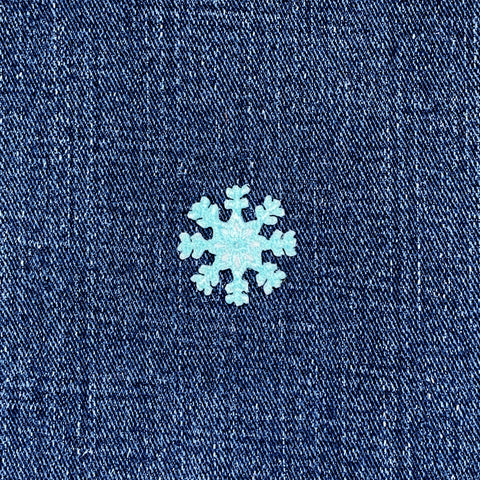 Snowflake design on a blue denim fabric background