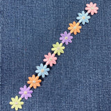 Patch of a row of colorful flowers on a denim background