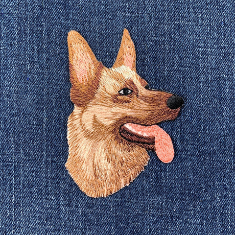 Embroidered german shepherd dog patch on a denim background