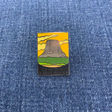 Pin with Devil's Tower National Monument design on a blue denim background