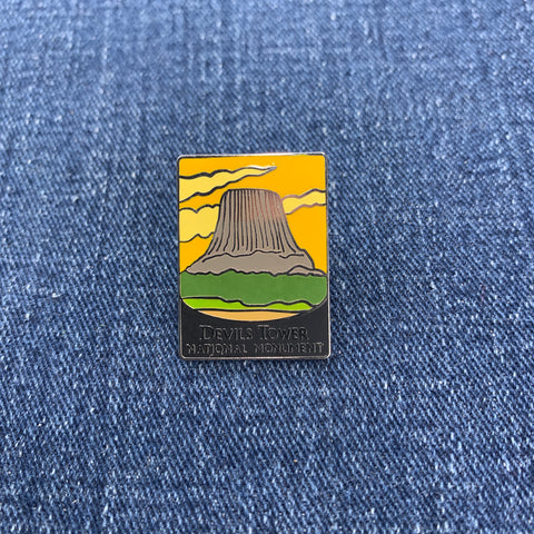 Pin with Devil's Tower National Monument design on a blue denim background