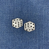 two embroidered dice patches on a denim background