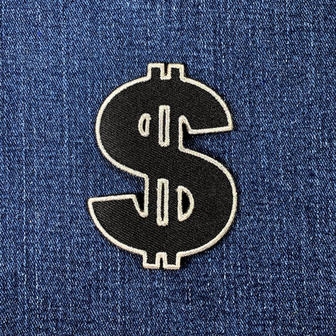 Black dollar sign patch on blue denim fabric