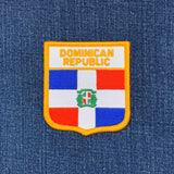 Embroidered patch of the Dominican Republic flag on a blue denim background
