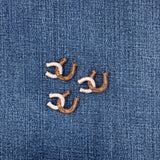 Embroidered horseshoe patches on a denim fabric background