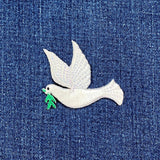 White dove patch with an olive branch on blue denim fabric