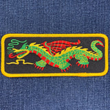 Embroidered dragon patch on denim fabric