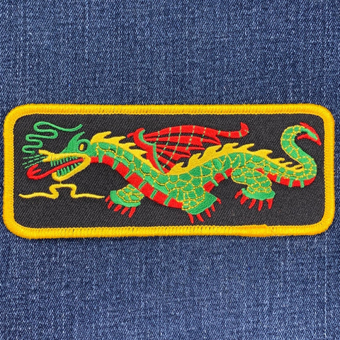Embroidered dragon patch on denim fabric