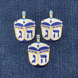 Three embroidered dreidels on a denim background
