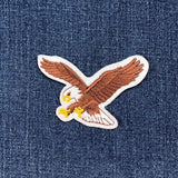 Embroidered eagle patch on a denim fabric background