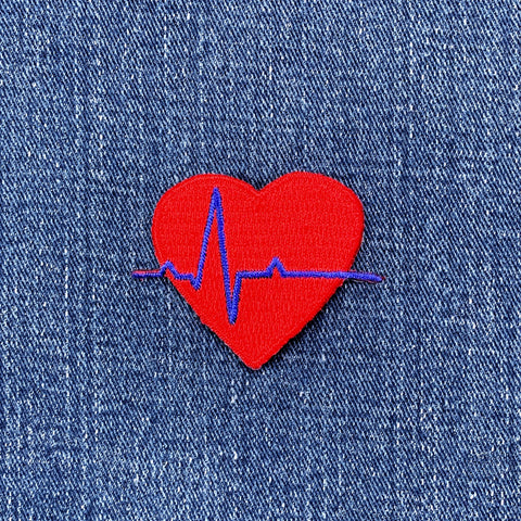 Red heart patch with blue heartbeat EKG line on denim fabric