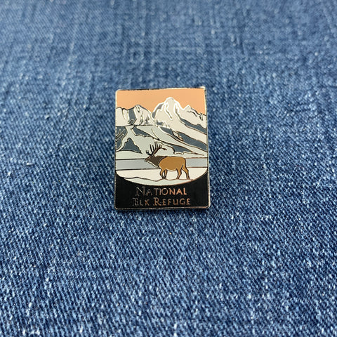 Pin with National Elk Refuge mountain and elk design on a denim background