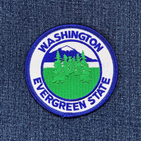 Embroidered patch with 'Washington Evergreen State' text and green trees on a blue denim background