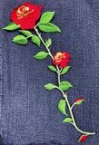 Embroidered red roses on denim fabric
