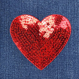 Red sequin heart patch on denim fabric
