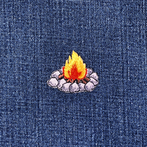 Embroidered campfire patch on denim fabric