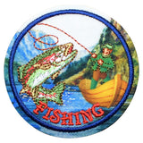 A circular embroidered patch featuring a fisherman in a yellow boat casting a line toward a large jumping fish over blue water, with the word “FISHING” stitched in red at the bottom.