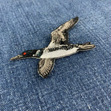 a flying loon embroidered patch on a denim background