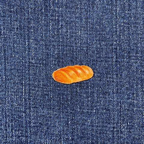 Small French bread patch on a blue denim fabric background