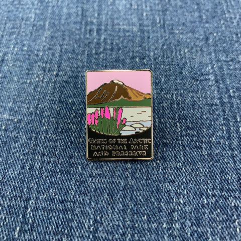 Pin with gates of the arctic national park mountain and flower design on a denim background